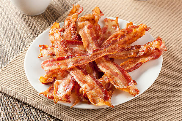 Cooked Greasy Bacon Cooked Greasy Bacon against a back ground cooked bacon slice stock pictures, royalty-free photos & images