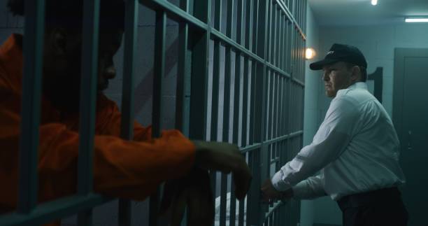 istock Warden brings guilty prisoner in jail cell 1608604302