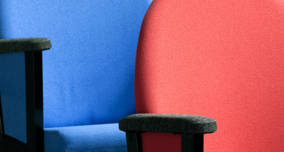Part of blue and red chairs in auditorium,