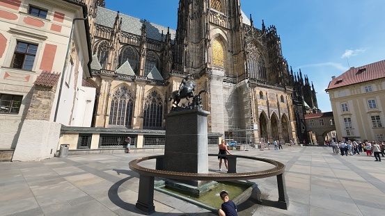 Prague, Czech - June 9, 2023: Statue of St. George and Dragon, with St. Vitus Cathedral in background, in Prague Castle, Czech Repubic.