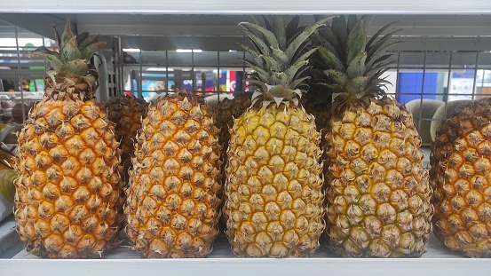 Fresh tropical fruit pineapple displayed on the rack of supermarket to attract the buyer