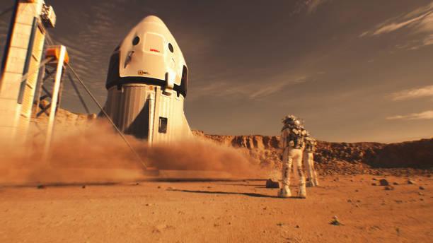 Two astronauts watch spacecraft landing on Mars surface