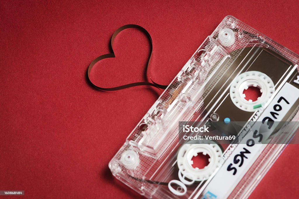 Valentine's day card template Audio cassette with magnetic tape in shape of heart on red background Audio Cassette Stock Photo