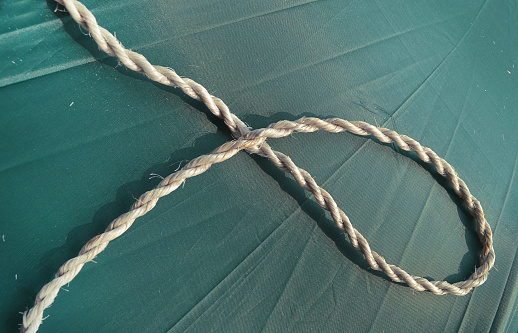 a piece of white old rope on a green cloth surface