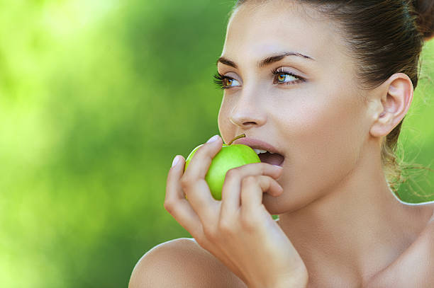 istock beautiful young woman with green apple 160883328