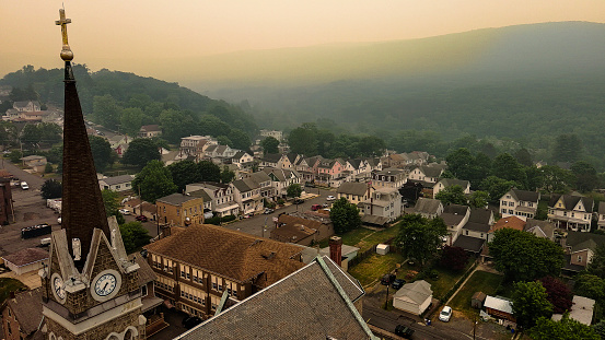 Fog and heat haze above St. Joseph's Catholic Church in Jim Thorpe (Mauch Chunk) residential district of nneighborhood. Appalachian Mountains, Poconos, Pennsylvania. Aerial view