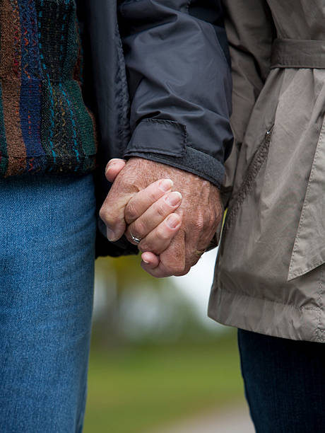 istock mature couple holding hands 160885276