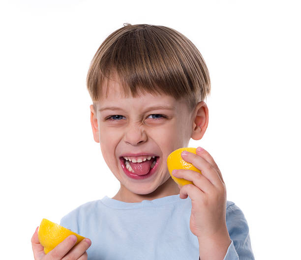 istock Grimace of young boy eating lemon 160889645