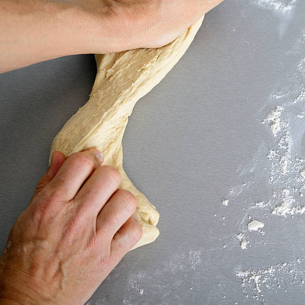Kneading dough Male kneading dough in domestic Kitchen. hott stock pictures, royalty-free photos & images