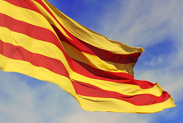 Waving flag of the Catalunya (Catalonia), Spain Waving flag of the Catalunya (Catalonia), Spain on background of the blue sky. catalonia stock illustrations