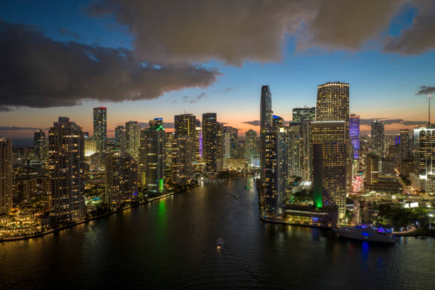 istock Brightly illuminated high skyscraper buildings in downtown district of Miami Brickell in Florida, USA. American megapolis with business financial district at night 1608964250