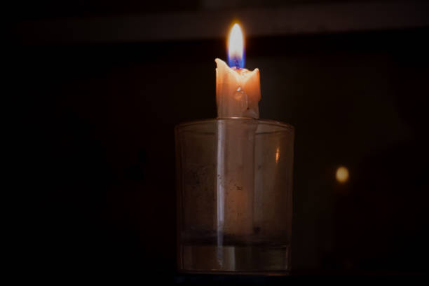 istock A glass cup containing a candle that burns in the darkness. 1608984085