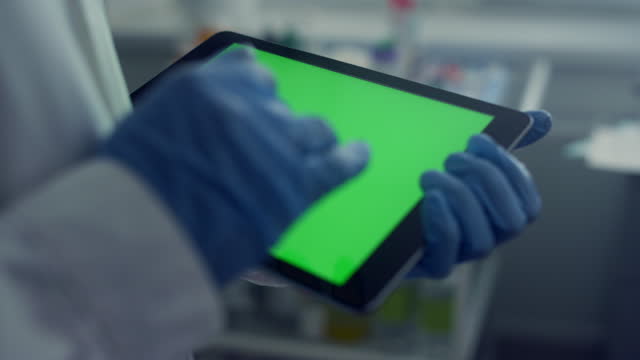 Doctor hands working chroma key tablet closeup touching screen with gloves