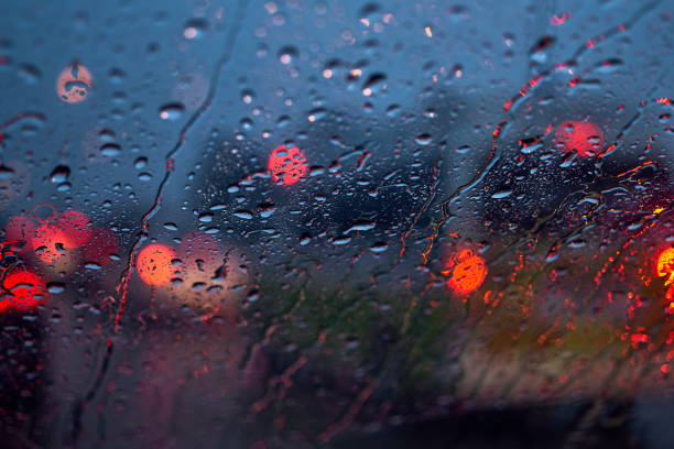 Light of the traffic and car on a rainy night through the windshield stock photo