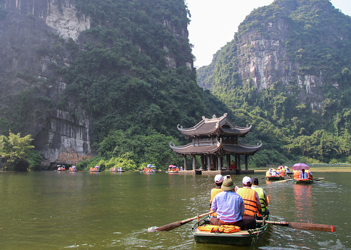 Tourists canoeing and sightseeing in Trang An eco tourism area, Ninh Binh province