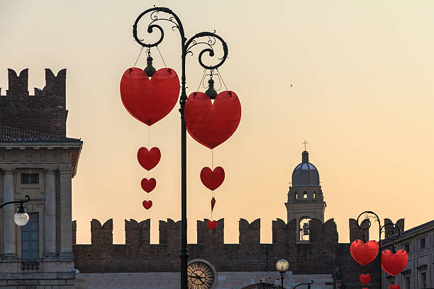Photo of the beautiful city of Venice in Italy showing a view looking up at old historical buildings castle tower and wall on a sunny summers day