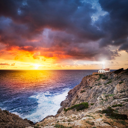 Shining lighthouse on the cliff by sunset. Far de Capdepera the easternmost point of Majorca(Spain).