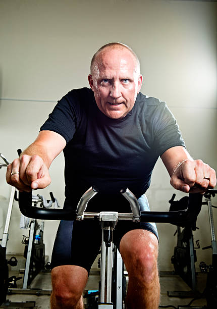 mid 40 s hombre tomando una clase de spinning - male1 fotografías e imágenes de stock