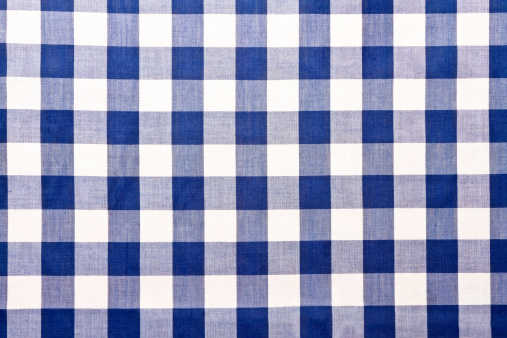 Close POV image of a Blue checkered gingham cloth showing lines of perspective into the distance.