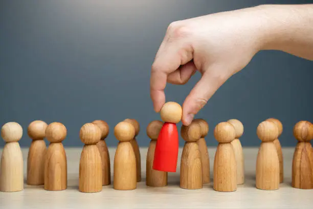 Photo of The hand selects a red person from the crowd.