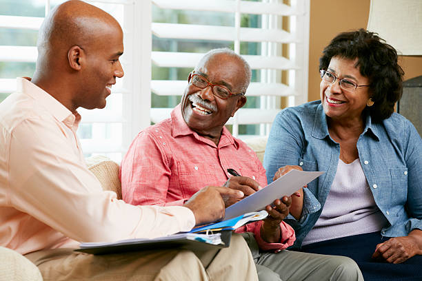 consulente finanziario, parlando di coppia senior a casa - retirement senior adult planning finance foto e immagini stock