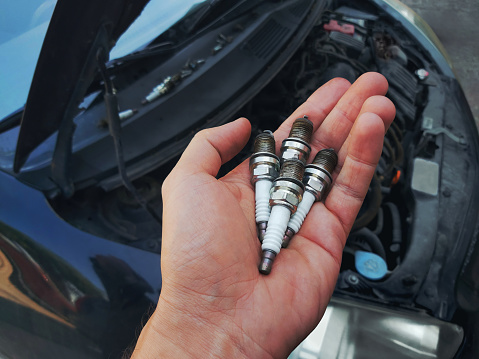 Old spark plugs in hand of technician