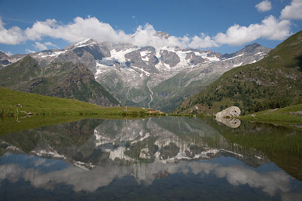 Monte Rosa with Clouds Monte Rosa withCloud reflected in mountain pond on Alagna Alpe Campo roberto alagna stock pictures, royalty-free photos & images