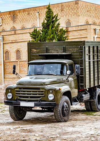 An old russian truck is parked in the courtyard of Chor Bakar in Uzbekistan