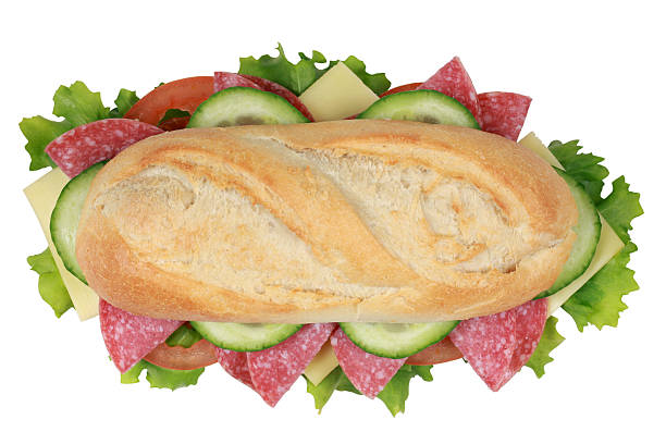 Top view of a sandwich with pepperoni, cheese, tomatoes, lettuce and cucumber