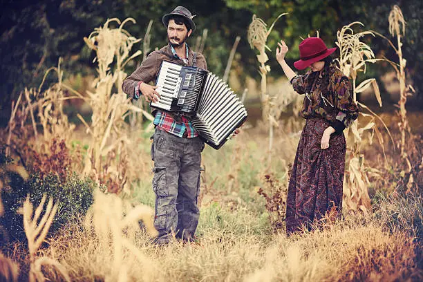 Photo of man playing accordion and girl dancing