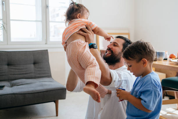 istock Happy Caucasian Man Playing with his Two Children at Home 1609207238