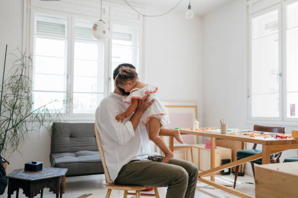 istock Unrecognizable White Man Sitting on a Chair and Holding his Daughter 1609207280