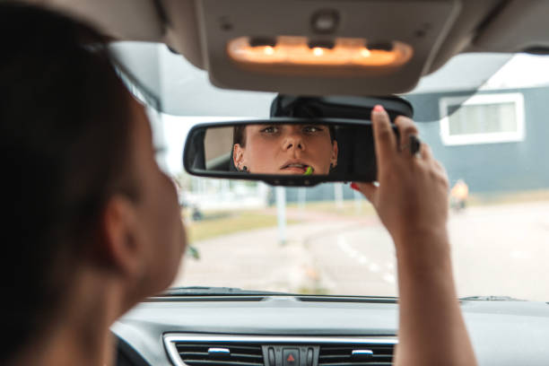 istock Distracted female driver doing her make-up at the wheel 1609233362