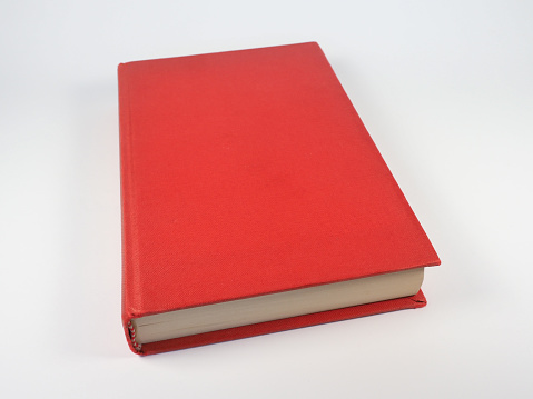 closed red book over off white background with copy space