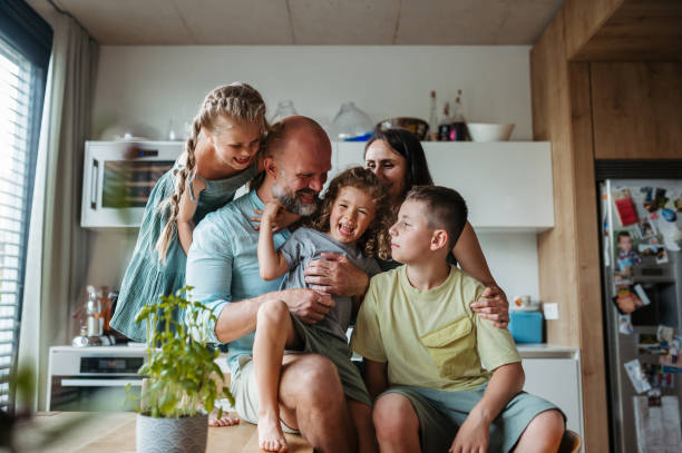 istock Cheerful family with three kids having fun together in kitchen. 1609238684