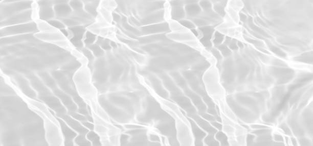 istock White water with ripples on the surface. Defocus blurred transparent white colored clear calm water surface texture with splashes and bubbles. Water waves with shining pattern texture background. 1609256356