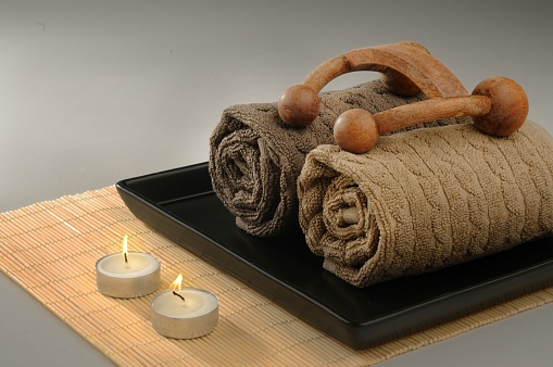 Spa concepts with massage tool, candles, towels and petals