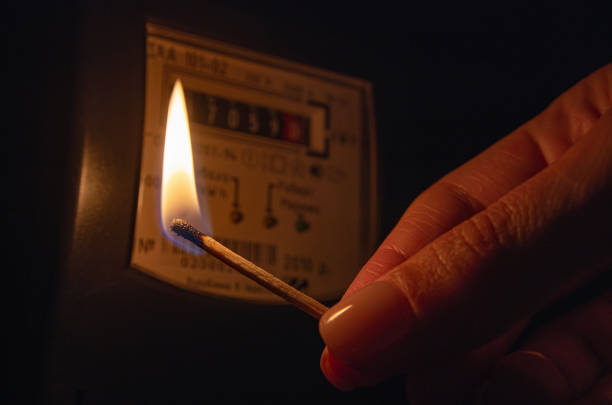 istock Burning matchstick near electric meter at home. 1609268184