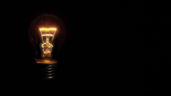 a incandescent light with voltage drop bulb on black background