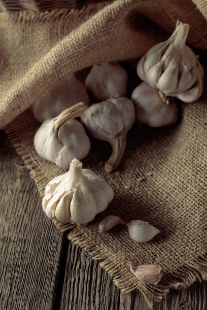 istock Garlic on an old wooden table. 1609325789