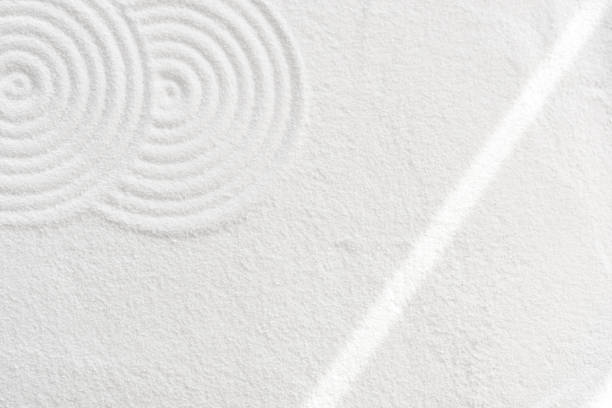 Japanese Zen Garden with concentric circles and with sunlight on white sandy texture surface background,Sand with simple spiritual patterns,Harmony,Meditation,Zen like concept