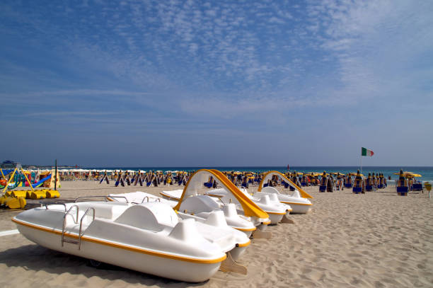 view of a walkway on Alimini beach with umbrellas under the sky with clouds