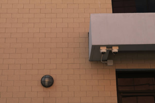 istock Surveillance cameras are a modern technology to prevent thieves and thieves that are installed on red brick construction as a wall to prevent thieves as well. 1609395563