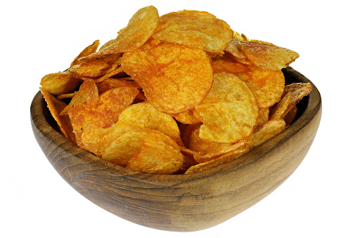 paprika flavored potato chips in a teakwood bowl isolated on white background