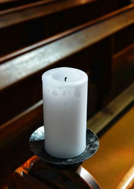 istock a white candle sitting on top of a table in a church 1609406721