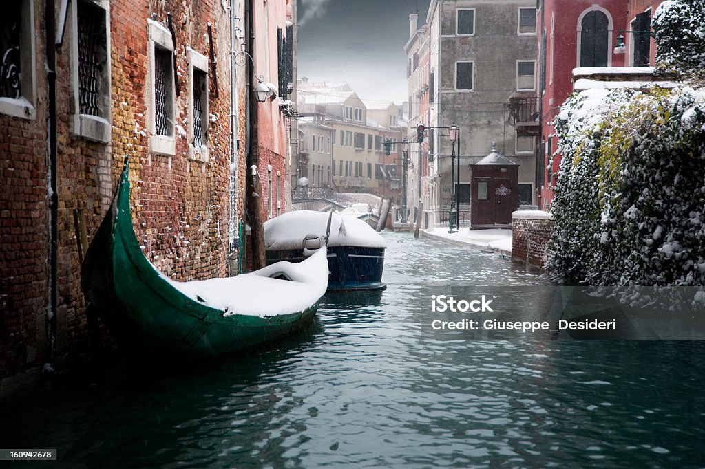 Venice in Winter Snow-covered gondolas in a Venice canal. Venice - Italy Stock Photo