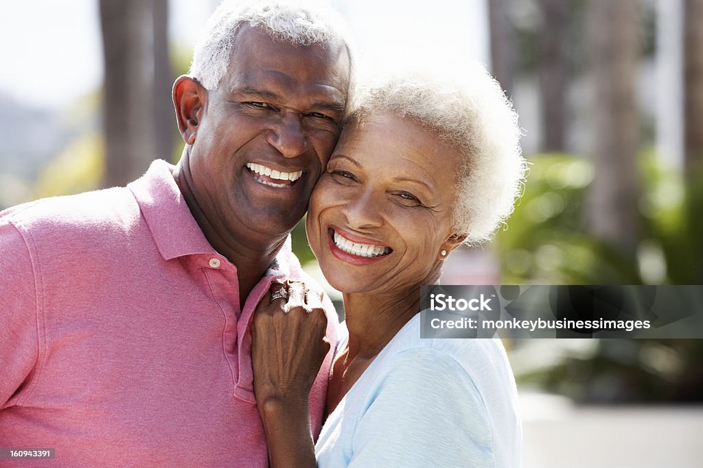 Portrait of romantic senior couple hugging in street Romantic Senior Couple Hugging In  Street Smiling To Camera Senior Couple Stock Photo