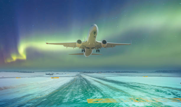 istock Commercical white airplane fly up over take-off runway the (ice) snow-covered airport with aurora borealis - Norway 1609438664