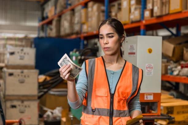 ingeniera de fábrica de almacén mujer trabajadora recibe bajo recorte disminución de salario grave aburrido sentirse mal después de ver su dinero en efectivo injusto ingresos salariales - low paid fotografías e imágenes de stock