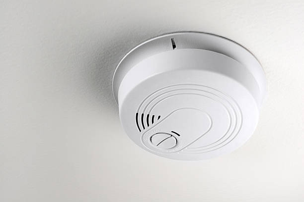 Smoke/Carbon Monoxide Detector A smoke detector installed on a ceiling smoke detector photos stock pictures, royalty-free photos & images